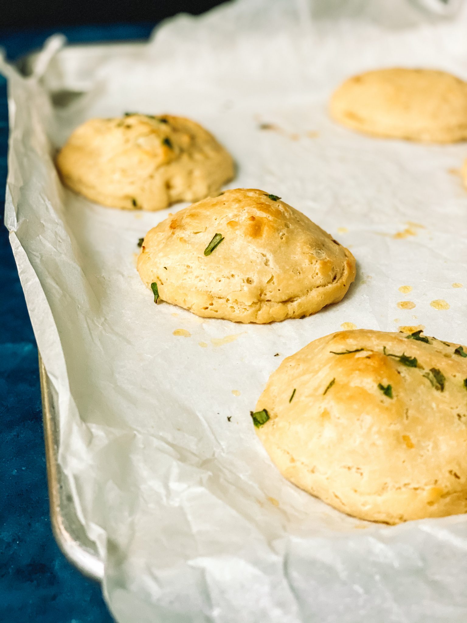 four cooked keto biscuits on parchment paper