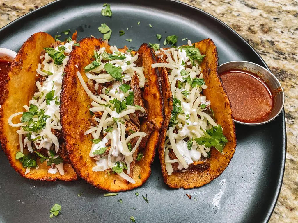 smoked beef barbacoa in corn tortillas with onions, cilantro and cheese