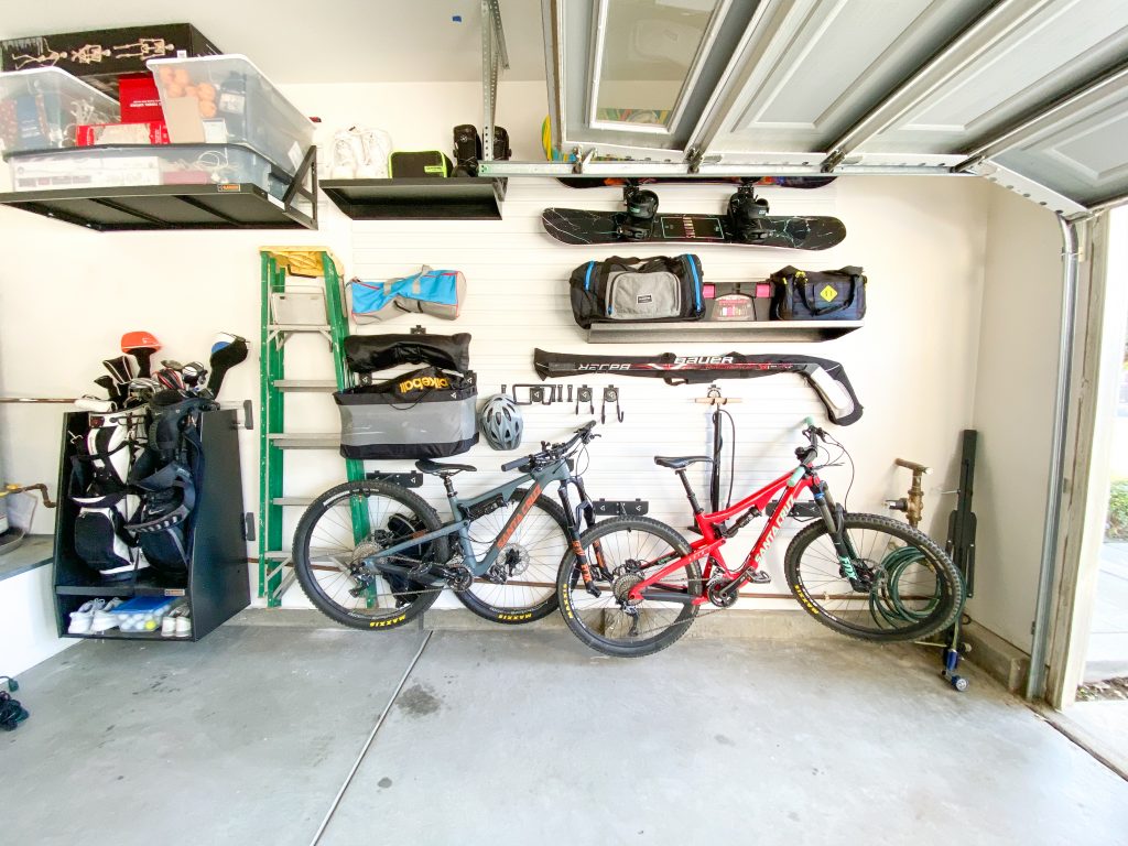 garage gear wall with bikes, hockey sticks, snowboards